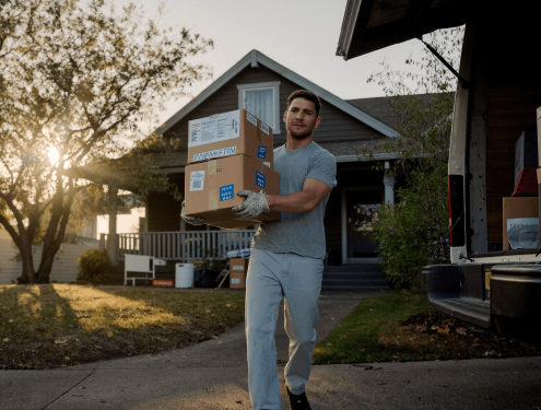 One-Day Jober carrying moving boxes to a truck in Austin